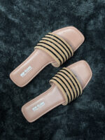 Women’s fancy flat sandals with gold and black accents and a neutral tan base.