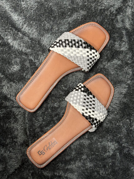 Handwoven leather slide sandals for women with black and white woven strap and durable brown leather sole.