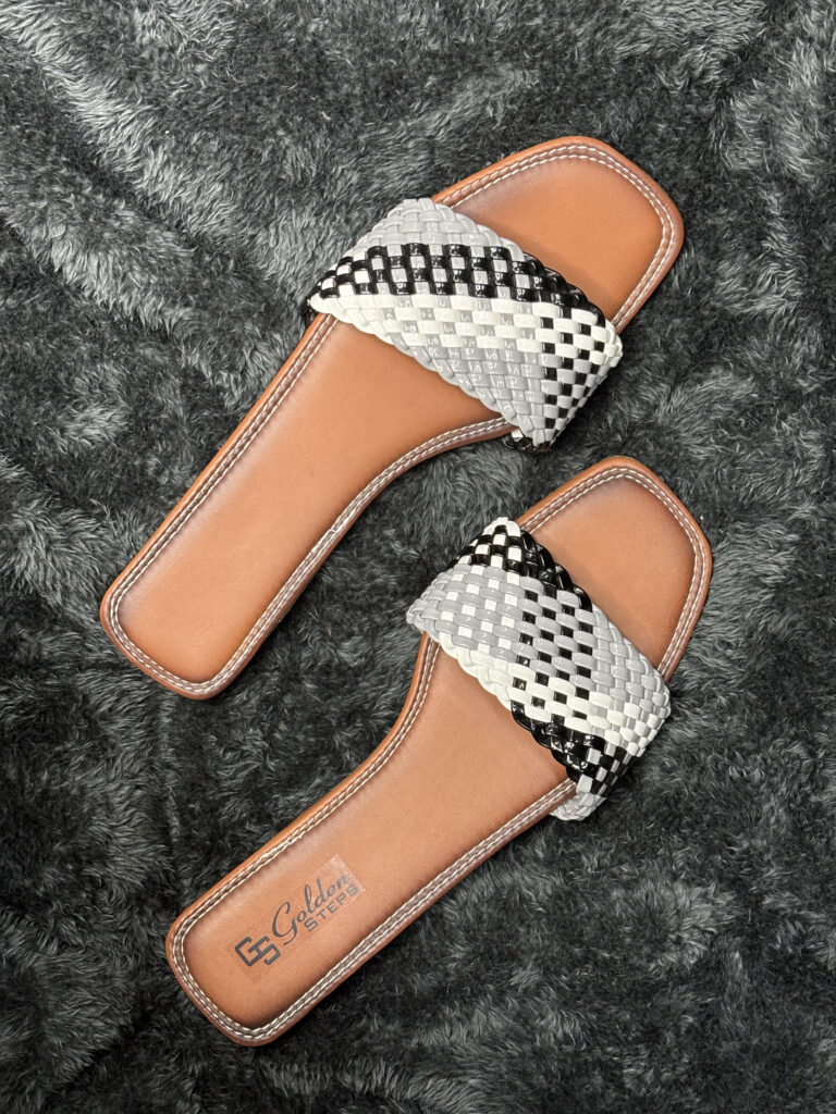 Handwoven leather slide sandals for women with black and white woven strap and durable brown leather sole.