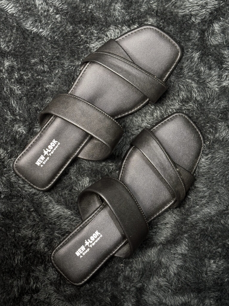 Black Crisscross Slip-On Flats with cushioned footbed and stylish overlapping straps, perfect for everyday wear.