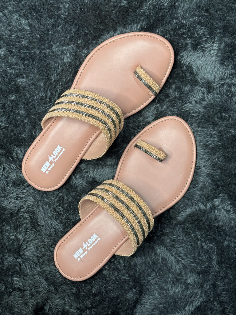 Ethnic gold and black women’s flats with intricate golden detailing, toe-ring strap, and cushioned sole, perfect for festive and traditional wear.
