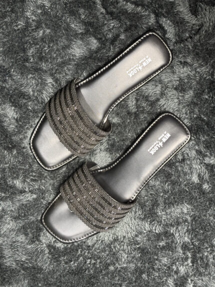 Glittery black flat sandals for women with a stylish metallic finish and slip-on design.