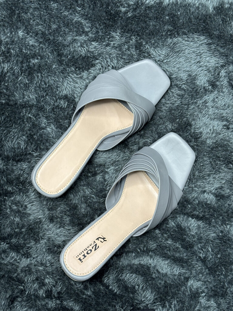 Grey slip-on flats for women with crisscross strap detailing and square-toe design, offering both comfort and style for casual, office, or semi-formal wear.