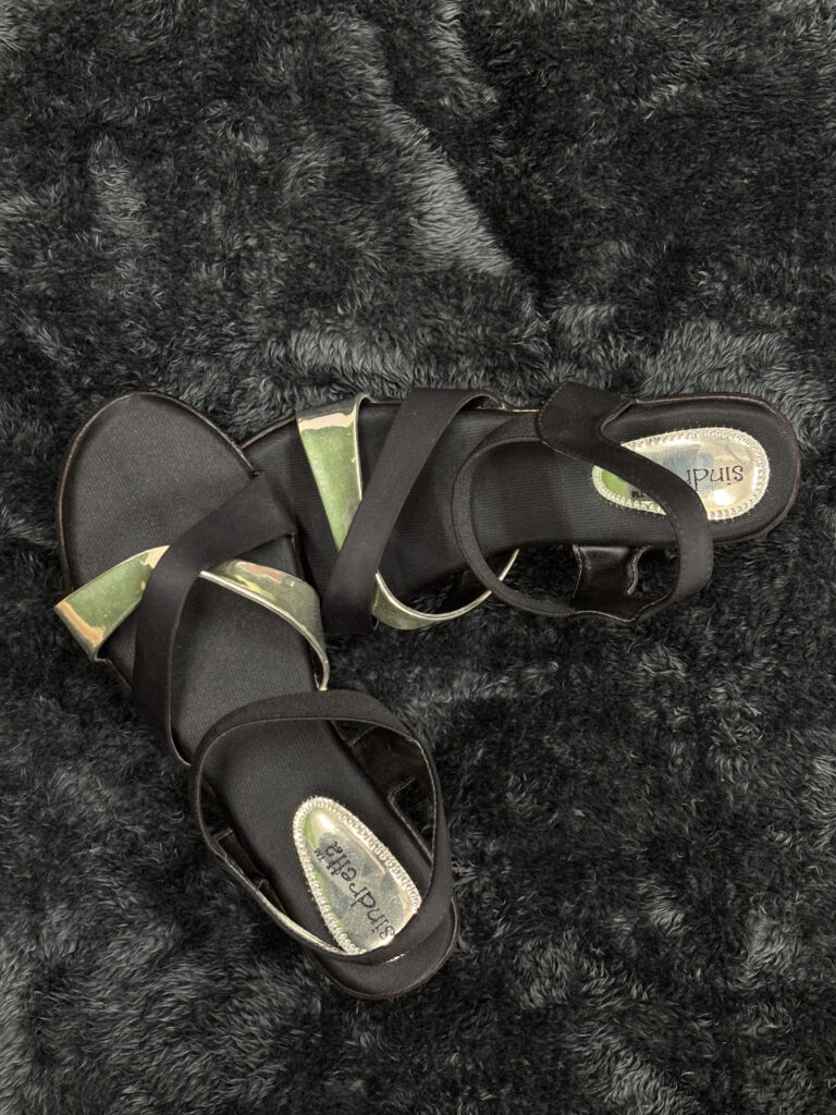 Alt Text: Black strappy sandals for women with a chic crisscross design and metallic accents, offering comfort and style for any occasion.