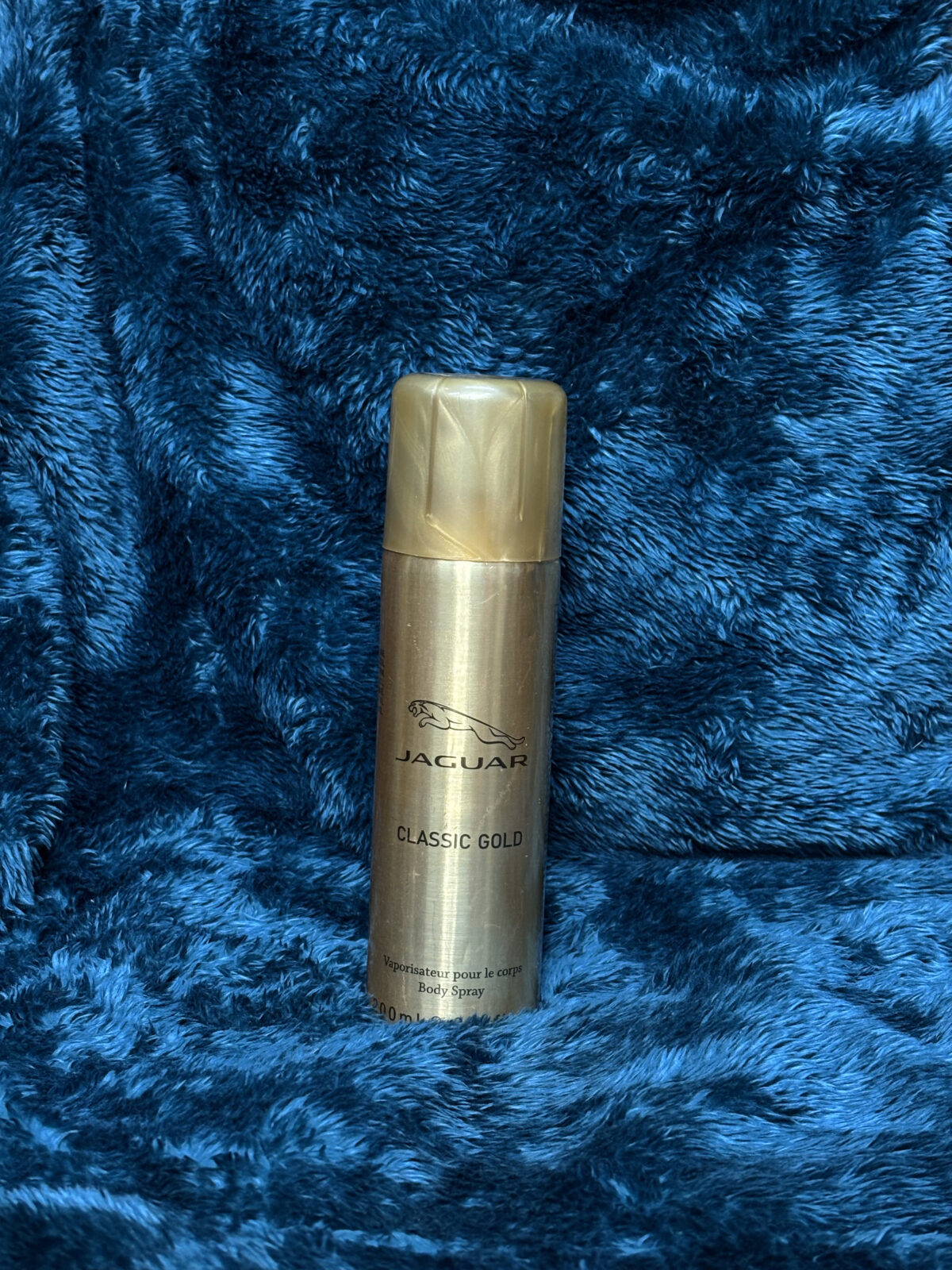 Jaguar Classic Gold Body Spray for Men in a sleek gold bottle, offering a fresh and long-lasting fragrance with apple, lime, and patchouli notes.