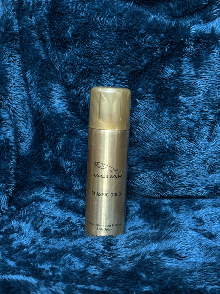 Jaguar Classic Gold Body Spray for Men in a sleek gold bottle, offering a fresh and long-lasting fragrance with apple, lime, and patchouli notes.